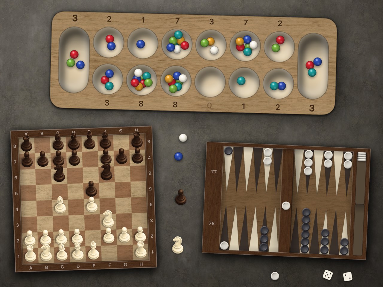 Three of the collection&rsquo;s boards on a grey stone table: a wooden mancala board with coloured seeds in its pits, a chess board mid-game with a taken pawn and knight standing beside it, and a backgammon board with the dice thrown on the table below.